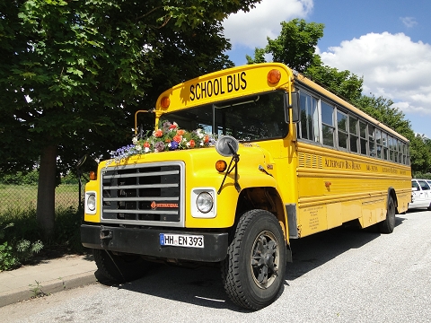 Schulbus für Hochzeiten: mit Blumenbouquet auf Kühlerhaube