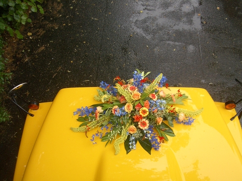 Schulbus mit Blumenbouquet auf Kühlerhaube für Hochzeiten